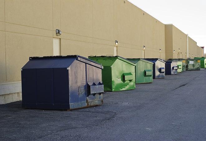 a construction worker empties a wheelbarrow of waste into the dumpster in Aledo, TX